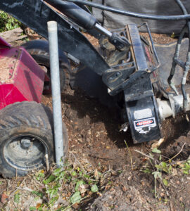 Machine grinding stump left after tree removal